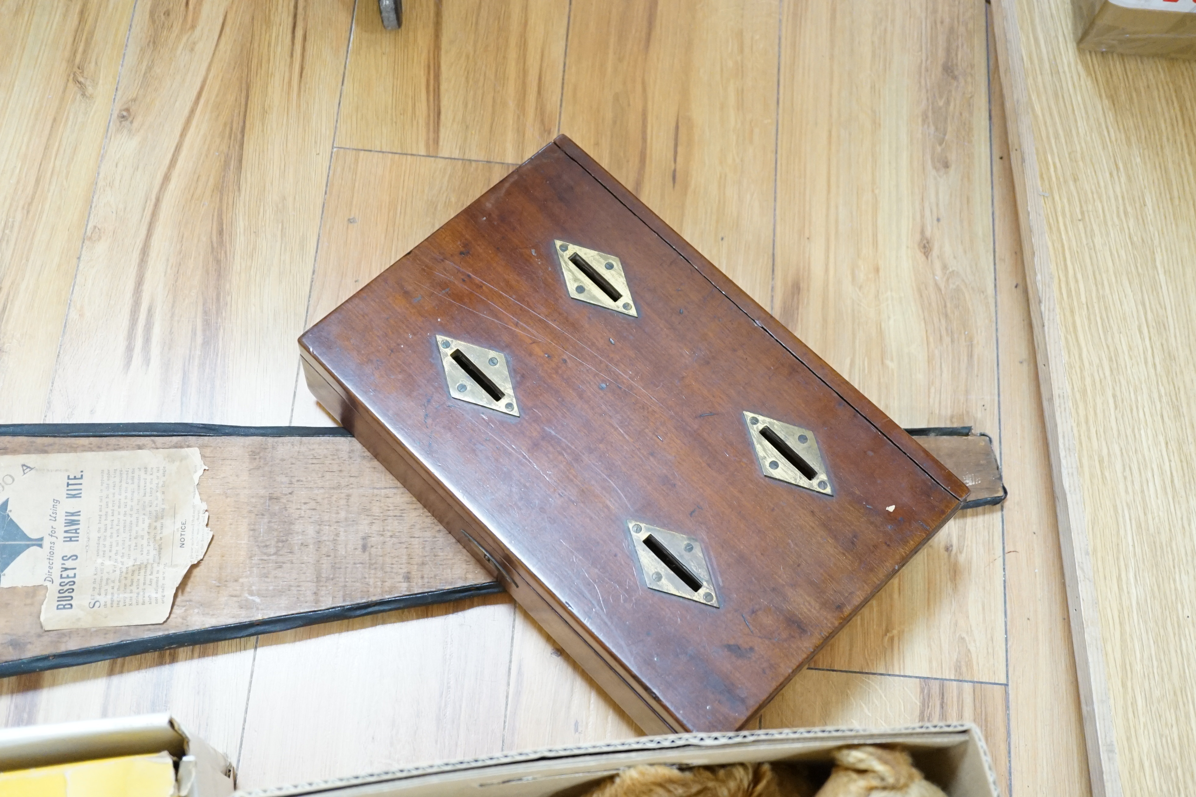 An early 20th century cased Bussey’s Hawk kite, a black walkie talkie doll, a four slot money box, an early Pelham puppet and two others, a hump backed teddy, together with various games and soft toys